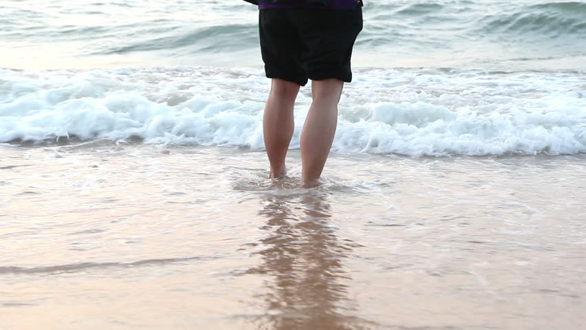 Swimmer Man Wetting And Conditioning Feet In Ocean Waves Washing Beach ...