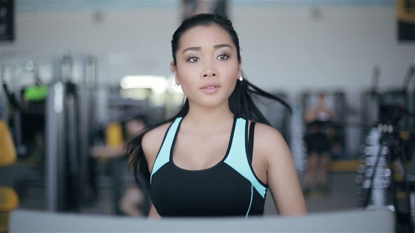 Attractive Asian Girl Running On The Treadmill In The Gym. Right ...