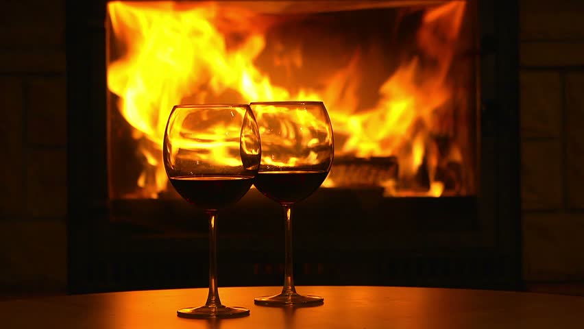 Glasses Of Wine On The Table In Front Of Flames Of Fireplace. Stock ...