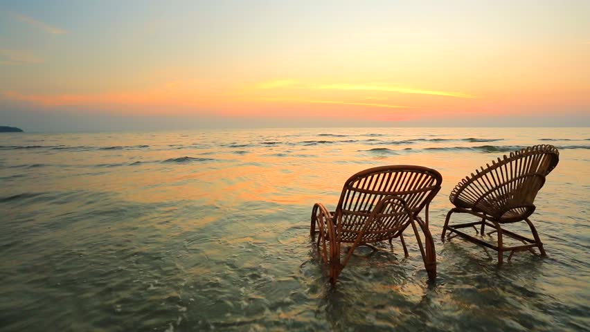 Sunset On A Beach. Two Empty Wooden Chairs Standing In A Water. Stock ...