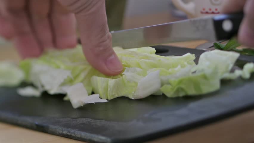 Kitchen Table Close Up close-up of chef hands slicing fresh parsley on wooden kitchen Kitchen Table Close Up close-up of chef hands slicing fresh parsley on wooden kitchen