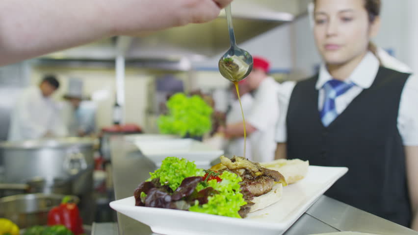 Restaurant Kitchen Video 4k clip. waitress collects her order from the chef in a busy hotel Restaurant Kitchen Video 4k clip. waitress collects her order from the chef in a busy hotel